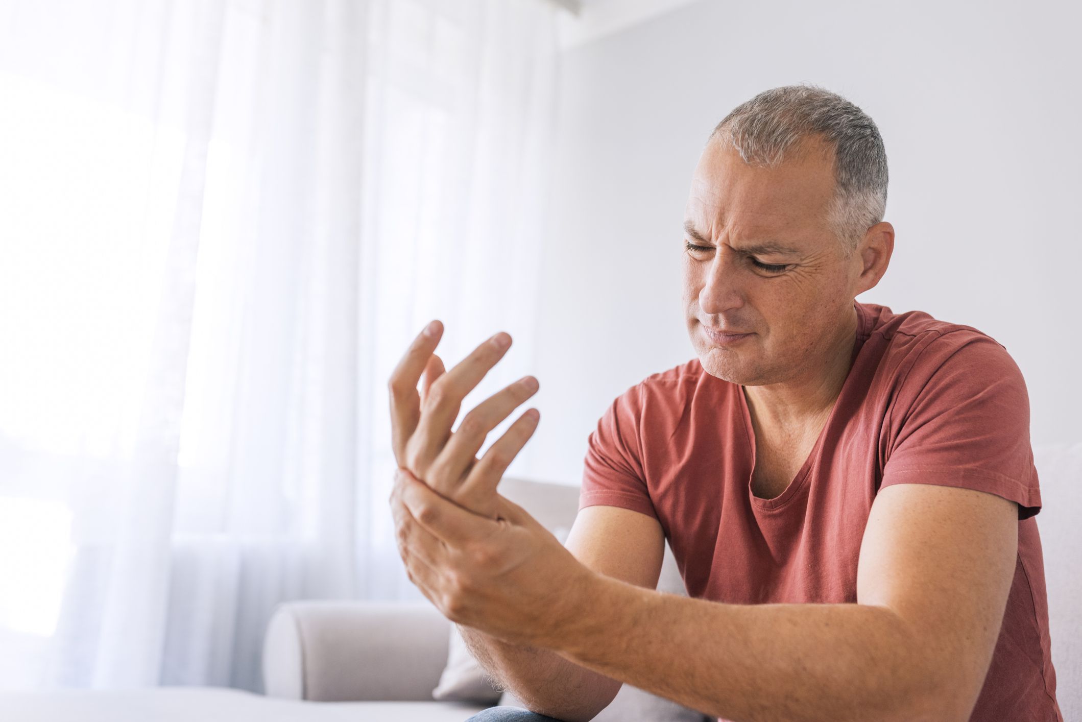 Photo of Mature man suffering from wrist pain at home while sittin on sofa during the day. Clenched painful hands (Photo of Mature man suffering from wrist pain at home while sittin on sofa during the day. Clenched painful hands, ASCII, 114 components